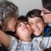 A joyful family of four sharing a warm embrace, highlighting love and togetherness indoors.